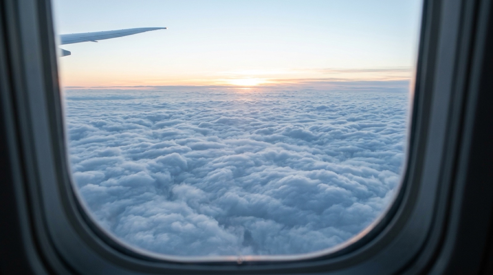 Sea of clouds at sunrise seen from an airplane window