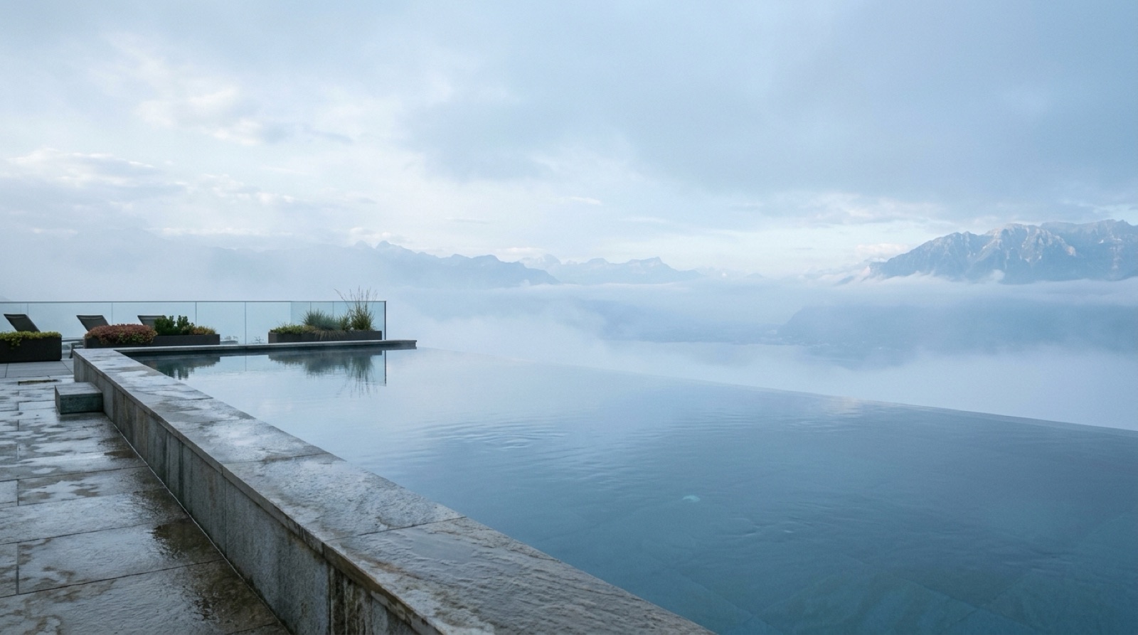Infinity pool merging into a hazy pale-blue morning sky